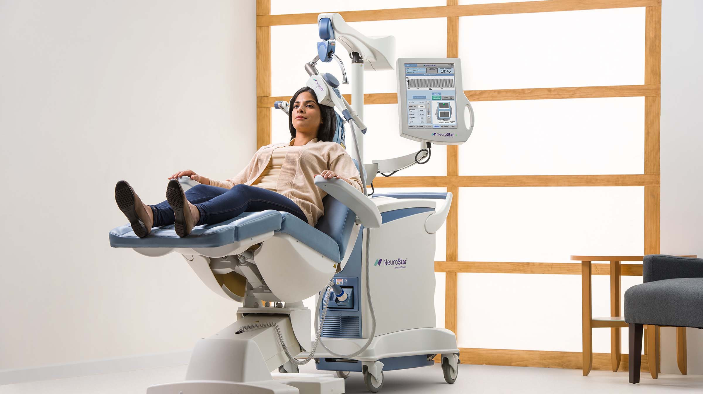 A woman sitting in an operating room chair.