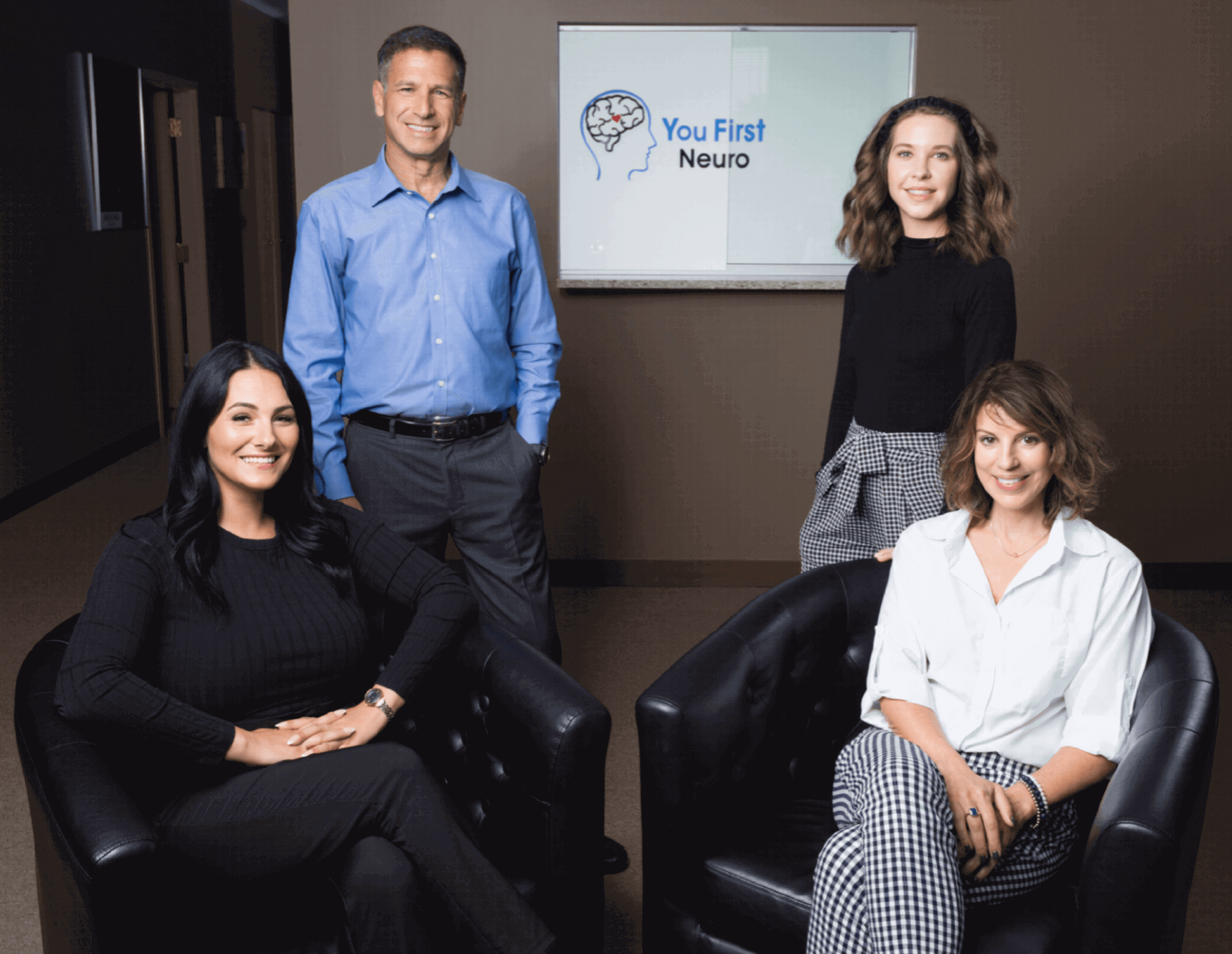 A group of people sitting in chairs posing for the camera.